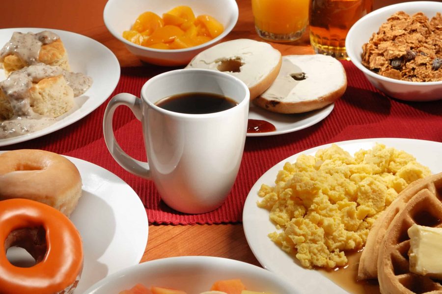 Breakfast Cup of coffee surrounded by plates of breakfast food